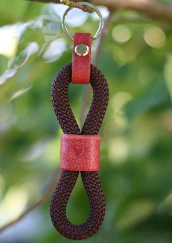 Klíčenka Venchim Klíčenka z lana v hnědé barvě, ozdobená červenou kůží s vyraženým srdcem.
